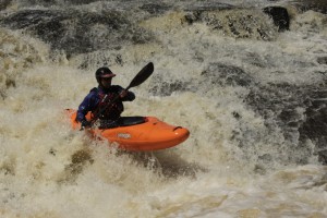 Roger Schumann kayaking a river rapid in Brazil.